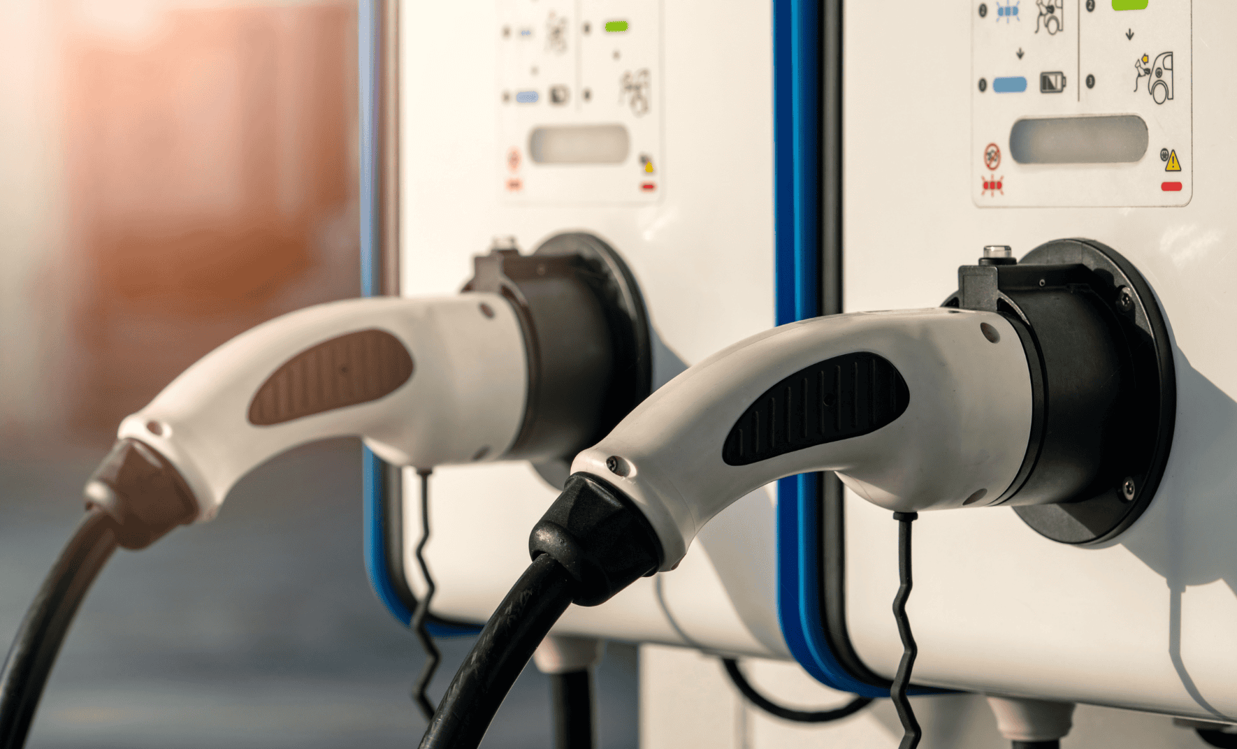 Electric vehicle charging stations with plugs connected.