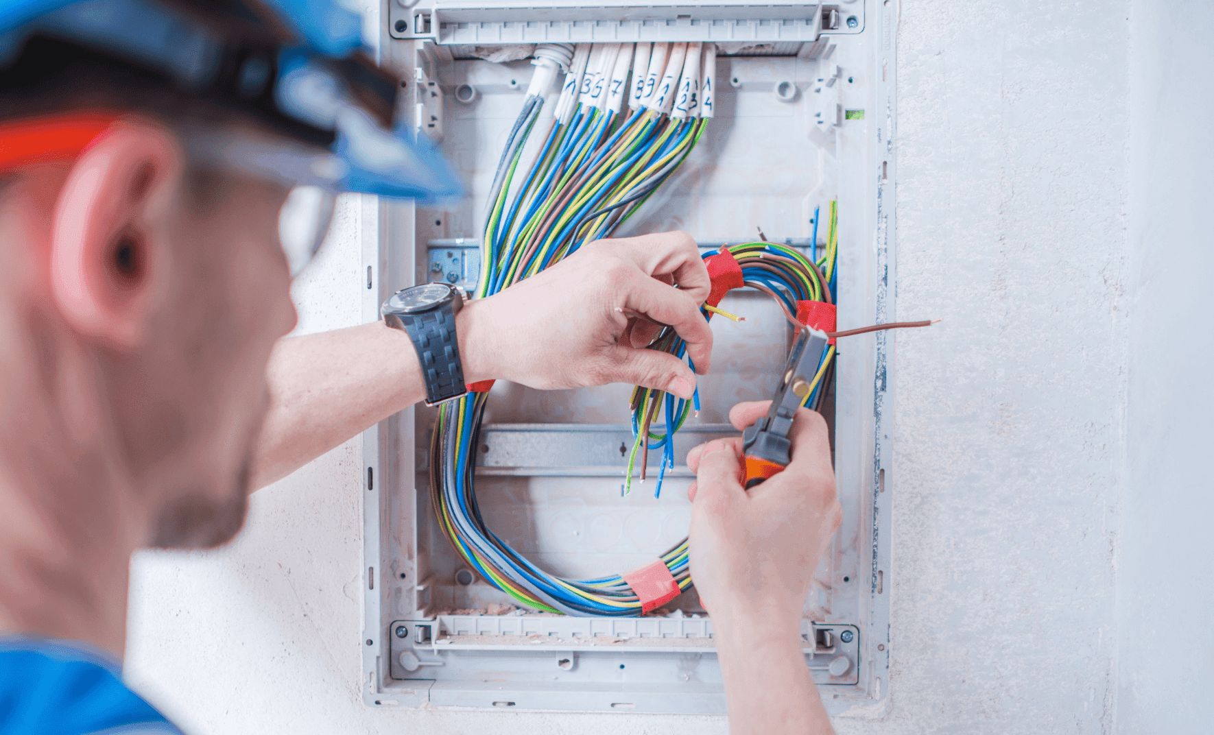 Electrician working on electrical panel wiring.