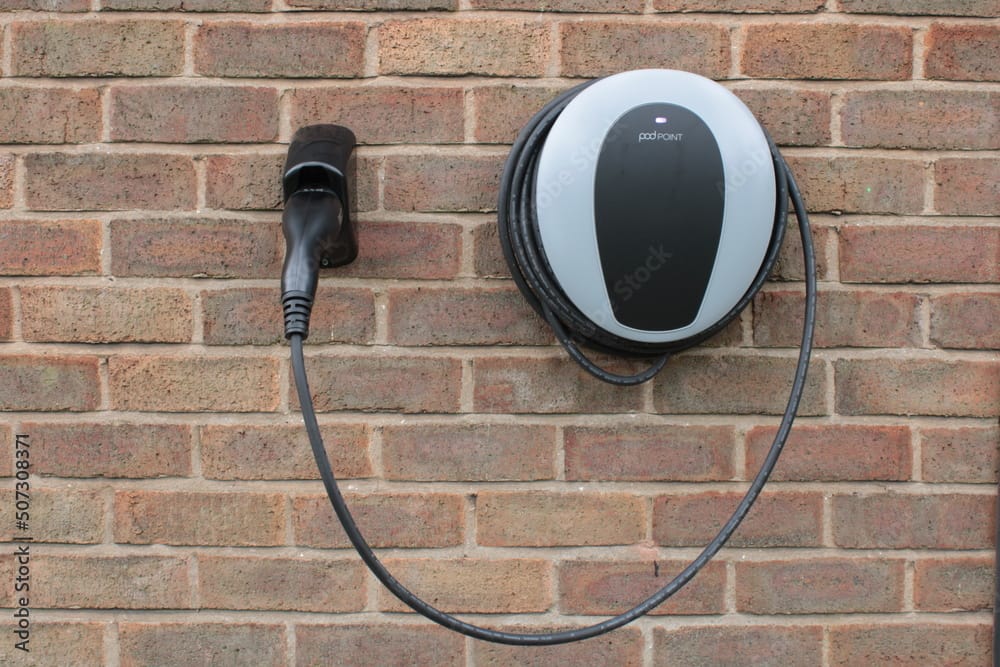Electric vehicle charging point on brick wall